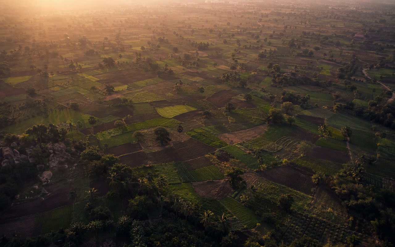 Aerial patchwork of small fragmented farmland plots at dawn